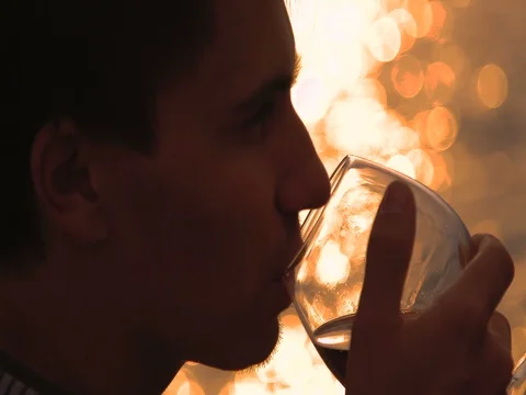 Man drinking bottle of wine during sunset near sea Stock Footage 80599165