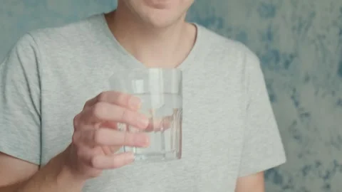 Man drinking capsule with omega 3, vitamin D with glass of water. Nutritional Stock Footage 252040812