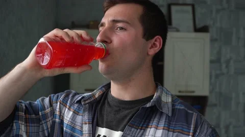 Man drinking cherry juice in a plastic bottle Stock Footage 142899499