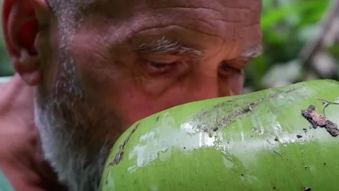 The man is drinking a coconut. Video stock 137940505