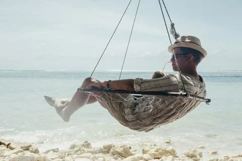 Man drinking coconut on the tropical beach at summer day Stock Photos