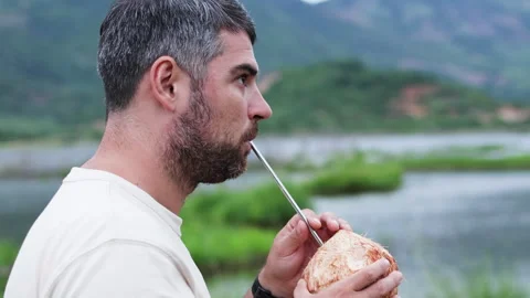 Man drinking coconut water on nature. Stock Footage 288830124