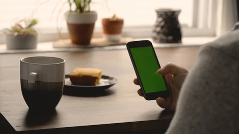 Man Drinking Cofee And Scrolling Through Cell Phone Apps Stock Footage 117692490