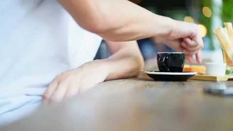 Man drinking coffee and bread in cafe shop with beautiful light bokeh background Stock Footage 93332696