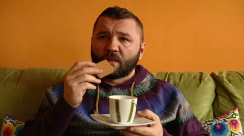  Man drinking coffee and eat sweet cookie at home    Stock Footage 61302707