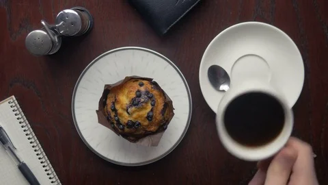 Man drinking coffee and eating a sweet cupcake at home Stock Footage 75545549