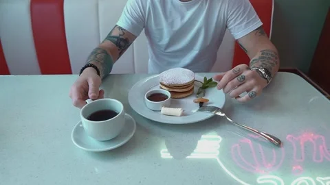 Man Drinking Coffee And Eating Pancakes At The Cafe Video stock 157292883
