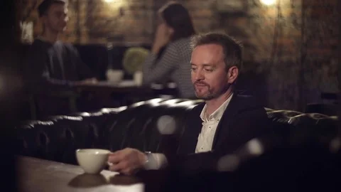 Man drinking coffee and looking out the window Video stock 69765153