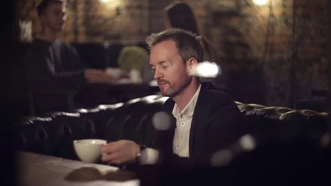Man drinking coffee and looking out the window Stock Footage 69844123