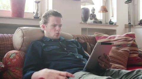 Man drinking coffee and reading on his tablet Stock Footage 40661680