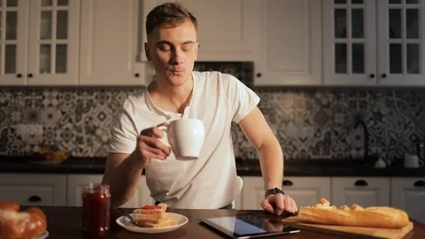 Man Drinking Coffee and Scrolling Tablet Видео 103828754