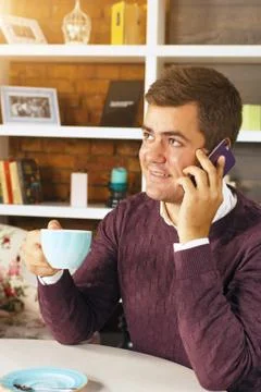 Man drinking coffee and talking on the phone Stock Photos