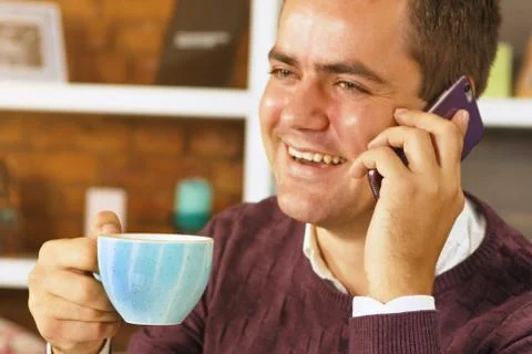 Man drinking coffee and talking on the phone Stock Photos