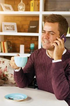 Man drinking coffee and talking on the phone Stock Photos