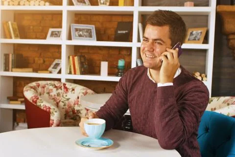 Man drinking coffee and talking on the phone Stock Photos