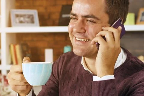 Man drinking coffee and talking on the phone Stock Photos