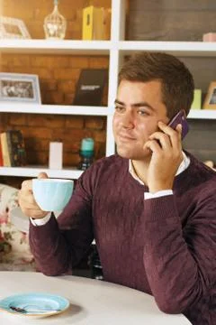 Man drinking coffee and talking on the phone Stock Photos