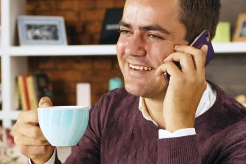 Man drinking coffee and talking on the phone Stock Photos