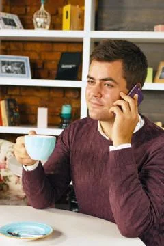 Man drinking coffee and talking on the phone Stock Photos