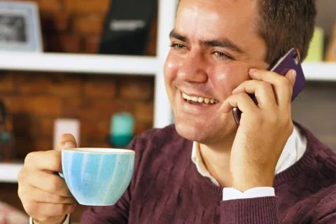 Man drinking coffee and talking on the phone Foto stock