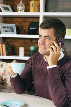 Man drinking coffee and talking on the phone Stock Photos