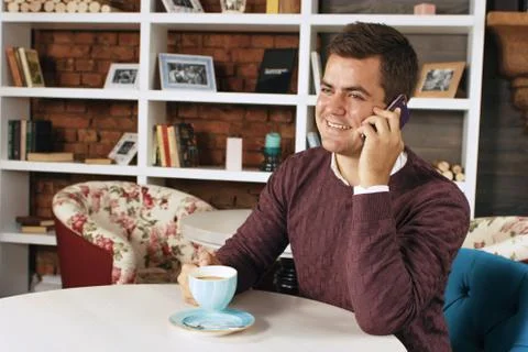 Man drinking coffee and talking on the phone Stock Photos