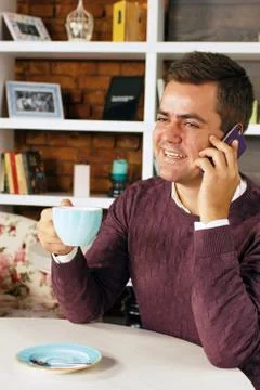 Man drinking coffee and talking on the phone Stock Photos