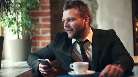 Man drinking coffee and texting by cellphone Stock Footage 55759315