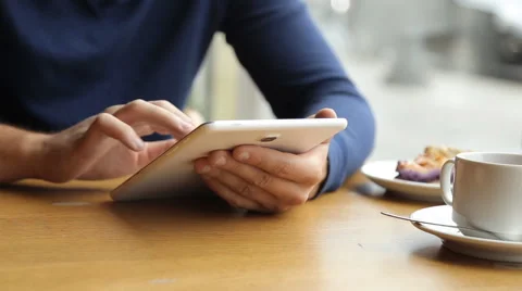 Man drinking coffee and using tablet in the cafe Stock Footage 67863095