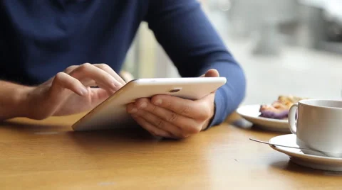Man drinking coffee and using tablet in the cafe Stock Footage 67863114