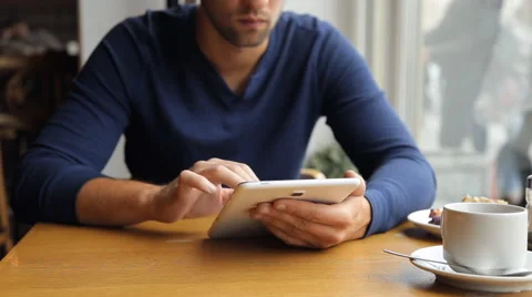 Man drinking coffee and using tablet in the cafe Stock Footage 67863131
