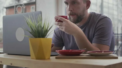 Man drinking coffee and using laptop Stock Footage 153133976