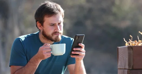 Man drinking coffee and using phone outdoors Stock Footage 175390785