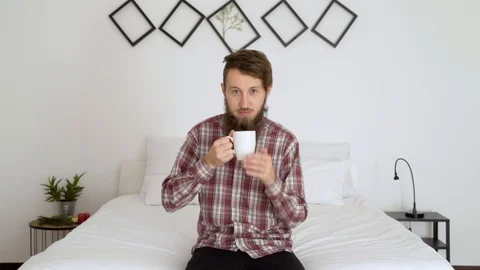 Man drinking coffee in an authentic room cheers to camera. Video stock 102655078