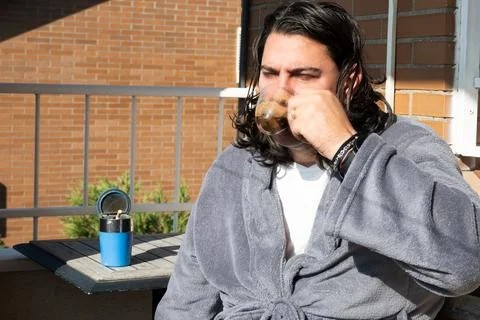 Man drinking coffee on balcony during morning routine Stock Photos