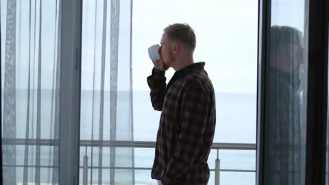 Man drinking coffee on the balcony overlooking the sea Stock-Footage 201052263