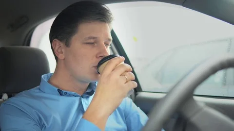 A man is drinking coffee in a car. 库存影片 81816879