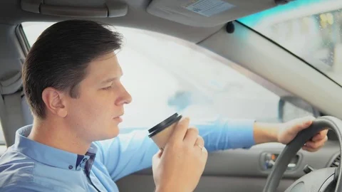 A man is drinking coffee in a car. Stock-Footage 81818638