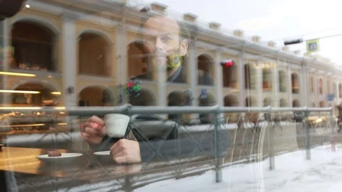 Man drinking coffee in a city cafe near the window and waiting for someone Stock Footage 71060558
