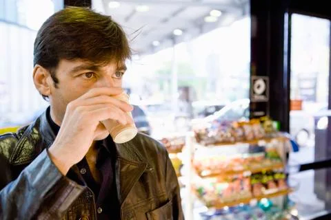Man drinking coffee in convenience store Stock Photos