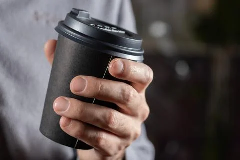 Man drinking coffee from disposable cup close up Stock Photos
