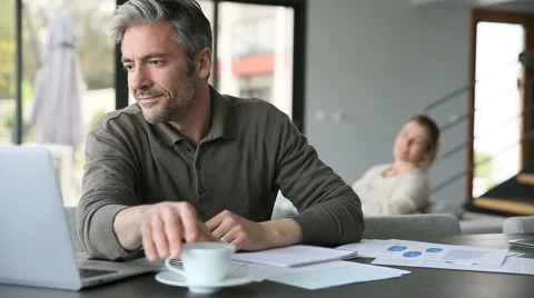 Man drinking coffee in front of laptop at home Stock Footage 48772300