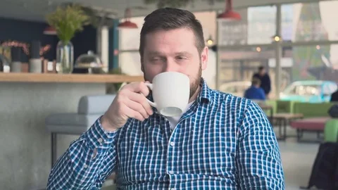 Man drinking coffee, looking at camera in cafe, portrait, steadicam shot  库存影片 72947567