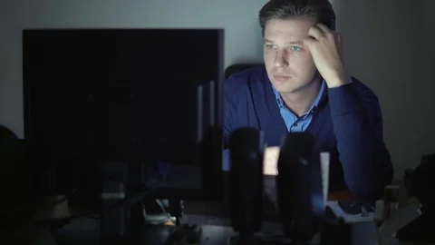 A man is drinking coffee in the office at night at the computer. Stock Footage 82542595