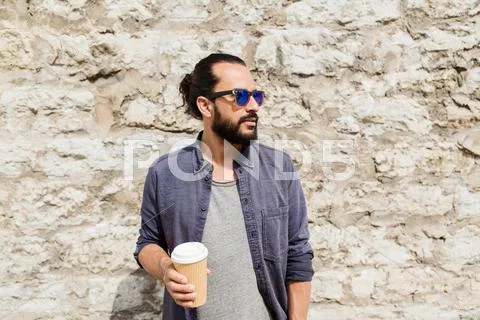 Man drinking coffee from paper cup on street Stock Photos