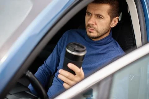 Man drinking coffee from reusable cup in car Stock Photos