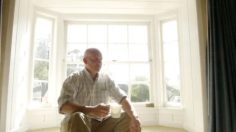 Man Drinking Coffee Sunny Window Video stock 75891183