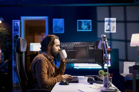 Man drinking coffee while doing software quality assurance, reading source code 写真素材