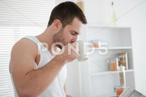 Man drinking coffee while reading the news Stock Photos