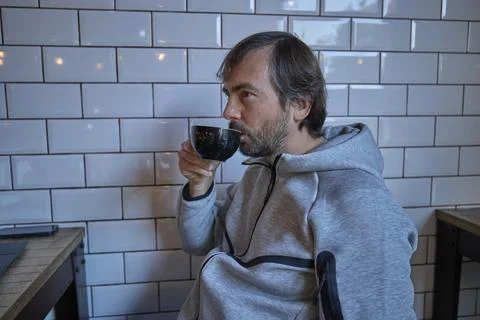 Man drinking coffee while sitting in modern cafe Stock Photos